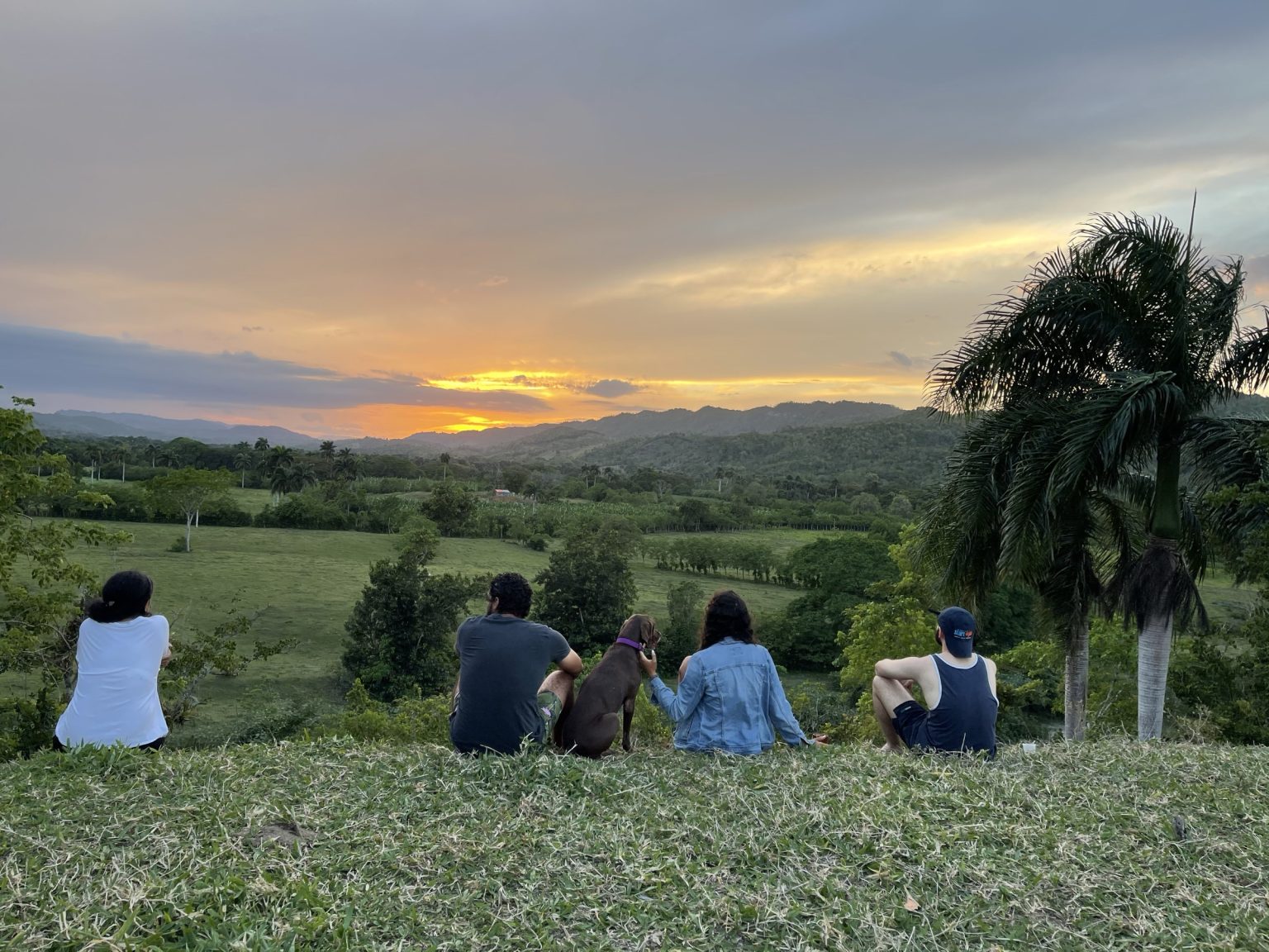 A group watching the sunset from a hillside in the Dominican Republic