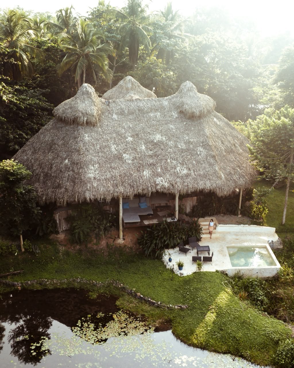A thatched eco-lodge cabin beside a pond in the forest, Dominican Republic